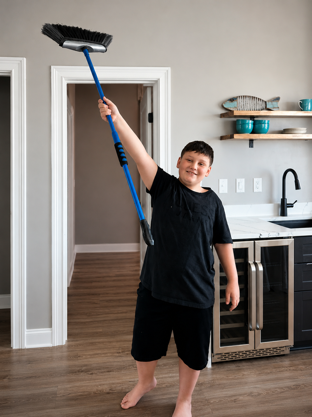 Ryden, son of Spectrum Sparkle Co. founder Kara, holding a broom